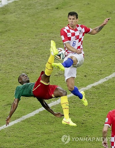 Cameroon's Pierre Webo (left) and Croatia's Dejan Lovren challenge for the ball during the group A World Cup soccer match between Cameroon and Croatia at the Arena da Amazonia in Manaus, Brazil, Wednesday, June 18, 2014. (AP-Yonhap)