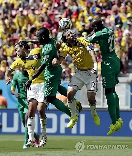 Colombia's Mario Yepes, second right, heads the ball during the group C World Cup soccer match between Colombia and Ivory Coast at the Estadio Nacional in Brasilia, Brazil, Thursday, June 19, 2014. (AP-Yonhap)
