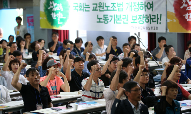 Members the Korean Teachers and Education Workers’ Union on Saturday shout slogans as they hold meetings to discuss the countermeasures for Thursday’s court ruling, in which the group was stripped of its legal status. (Yonhap)