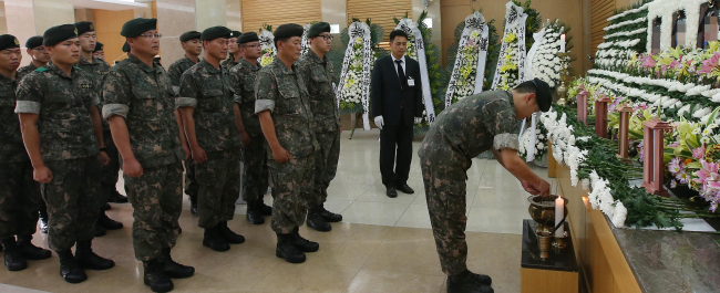 Soldiers pay respects at a memorial altar for the five soldiers who were killed in a shooting rampage in a border unit of the Army’s 22nd Division on Saturday, at a military hospital in Seongnam, Gyeonggi Province, Tuesday. ( Yonhap)