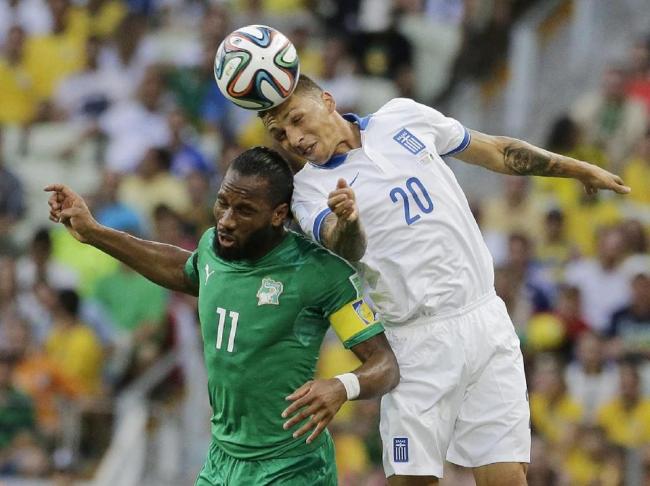 Greece`s Jose Holebas heads the ball over Ivory Coast`s Didier Drogba during the group C World Cup soccer match between Greece and Ivory Coast at the Arena Castelao in Fortaleza, Brazil, Tuesday. (AP)