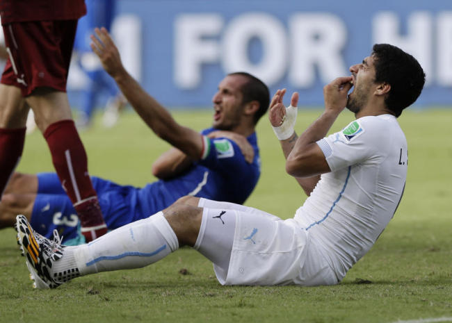 Uruguay's Luis Suarez holds his teeth after running into Italy's Giorgio Chiellini's shoulder during the group D World Cup soccer match between Italy and Uruguay at the Arena das Dunas in Natal, Brazil, Tuesday. (AP)