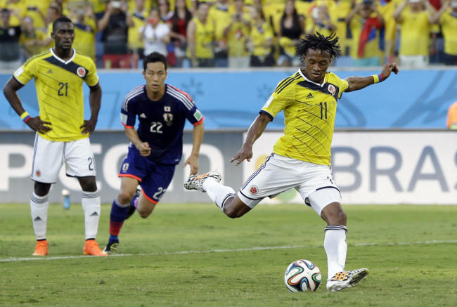 Colombia`s Juan Cuadrado scores the opening goal from the penalty spot during the group C World Cup soccer match between Japan and Colombia at the Arena Pantanal in Cuiaba, Brazil, Tuesday. (AP)
