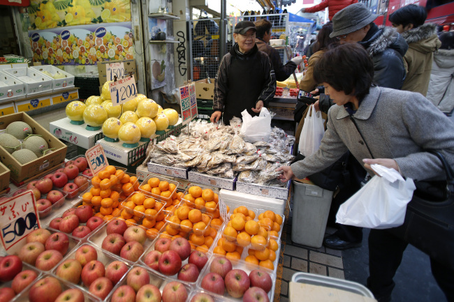 Customers shop for dried sweet potatoes at a market in the Ueno district of Tokyo. (Bloomberg)