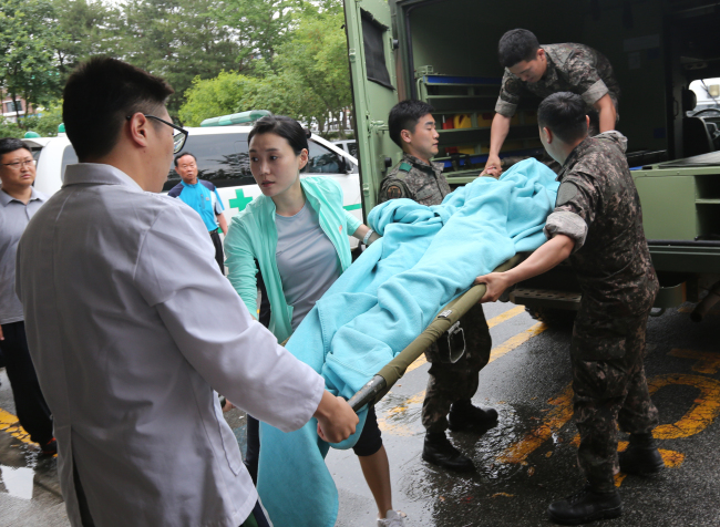 Medical staff move a soldier posing as the sergeant who was captured after a shooting spree last week to an emergency center at a hospital in Gangneung, Gangwon Province, Monday. (Yonhap)