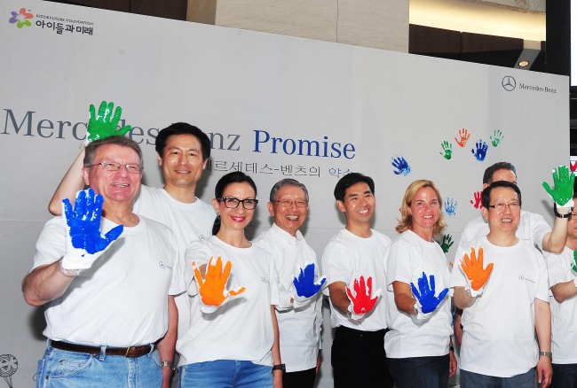 Mercedes-Benz Korea CEO Britta Seeger (second from right) and other executives of Daimler Group’s local operations and dealers pose at the launch of the carmaker’s social responsibility program “Promise” at the IFC Mall in Yeouido, Seoul, Sunday. (Mercedes-Benz Korea)