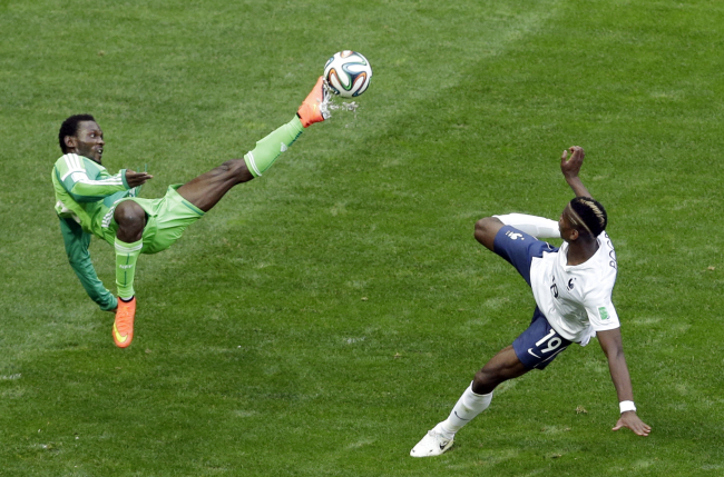 Nigeria's Juwon Oshaniwa, left, and France's Paul Pogba challenge for the ball during the World Cup round of 16 soccer match between France and Nigeria at the Estadio Nacional in Brasilia, Brazil, Monday, June 30, 2014. (AP-Yonhap)