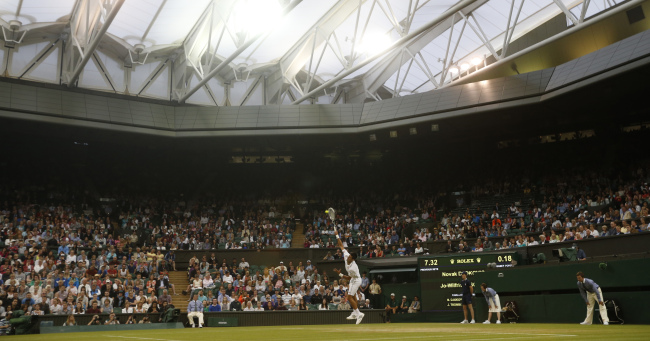 Novak Djokovic serves to Jo-Wilfried Tsonga at the Wimbledon on Monday. (AP-Yonhap)