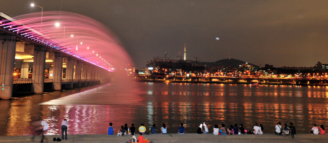 People watch the rainbow fountain show at Banpo Bridge in Seoul. (Kim Myung-sub/The Korea Herald)