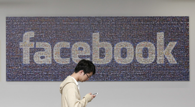 man walks past a Facebook sign at Facebook’s campus in Menlo Park, California. (AP-Yonhap)