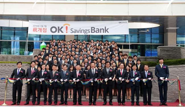 Apro Service Group executives attend a tape-cutting ceremony to mark the opening of OK Savings Bank and OK2 Savings Bank on Monday. The group, known for the leading private lender Rush & Cash, recently expanded its business by acquiring Yeju Savings Bank and Yenarae Savings Bank. (Apro Financial Group)