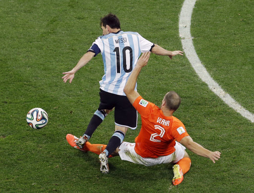 Netherlands' Ron Vlaar tackles Argentina's Lionel Messi during the World Cup semifinal soccer match between the Netherlands and Argentina at the Itaquerao Stadium in Sao Paulo Brazil, Wednesday, July 9, 2014. (Yonhap-AP)
