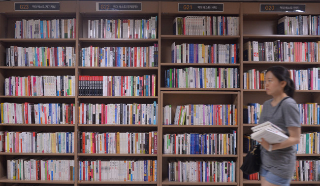 A customer passes by bookshelves at the Jongno shop of Aladdin Used Books chain, which opened in 2011 in a basement of a building that had housed a nightclub. (Lee Sang-sub/The Korea Herald)