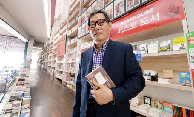 Kim Eoun-ho, president of the publishing house Hangilsa, poses with his book “The Forest of Books, Sound of Books,” which chronicles his 39 years of publishing. (Park Hyun-koo/The Korea Herald)