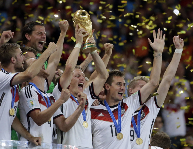Germany's players celebrate with the World Cup trophy after winning the 2014 FIFA World Cup final football match between Germany and Argentina 1-0 following extra-time at the Maracana Stadium in Rio de Janeiro, Brazil, on Sunday. (AP-Yonhap)