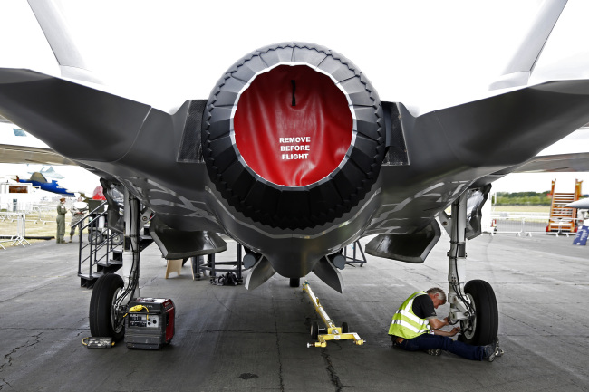 A worker checks the landing gear of a model of a F-35 Lightning II joint strike fighter jet, produced by Lockheed Martin Corp., as it stands on display prior to the opening of the Farnborough International Airshow in England on Sunday. (Bloomberg)