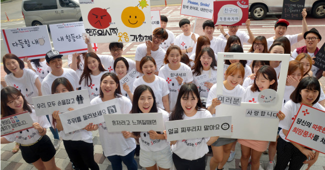 Students participate in the “Please Smile” campaign hosted by the Red Cross at its headquarters in central Seoul to perk up the national mood in the wake of the Sewol ferry disaster. (Kim Myung-sub/The Korea Herald)