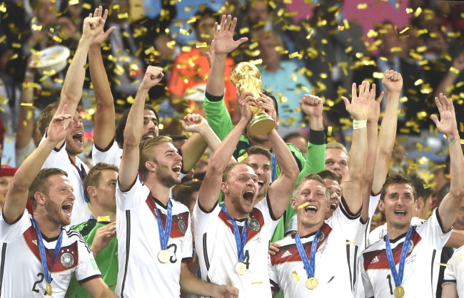 Germany’s Benedikt Howedes holds the FIFA World Cup trophy as Germany’s players celebrate their victory in the final against Argentina at the Estadio do Maracana in Rio de Janeiro, Brazil, Sunday. (Xinhua-Yonhap)