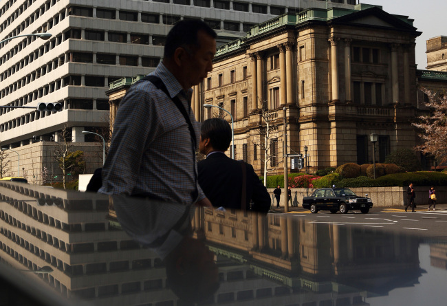 Pedestrians walk past the Bank of Japan headquarters in Tokyo. (Bloomberg)