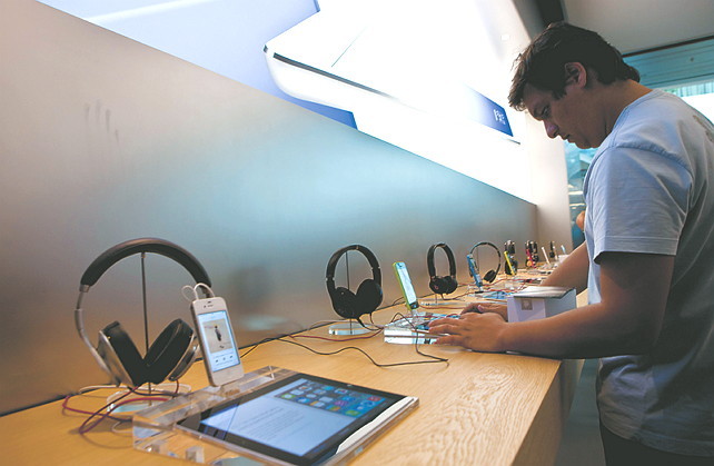 A customer tries an Apple Inc. iPad during the opening of the first Apple store in Latin America, located at the Village mall in Rio de Janeiro. (Bloomberg)