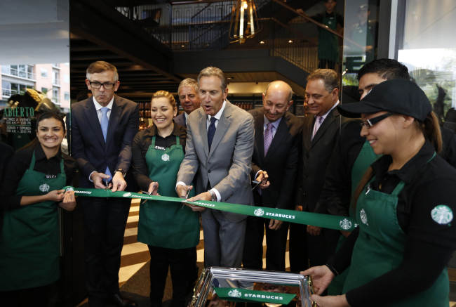 Starbucks CEO Howard Schultz (center) takes part in the opening ceremony of the first Starbucks in Colombia on Wednesday. (AP-Yonhap)