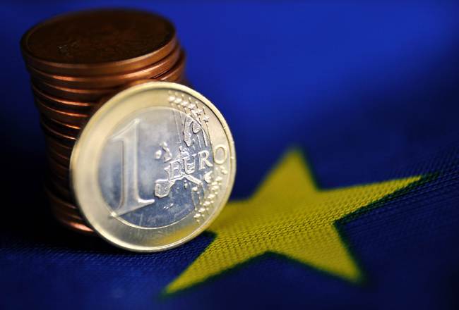 A 1 euro coin and a pile of eurocents is displayed on a European Union flag. (AFP-Yonhap)