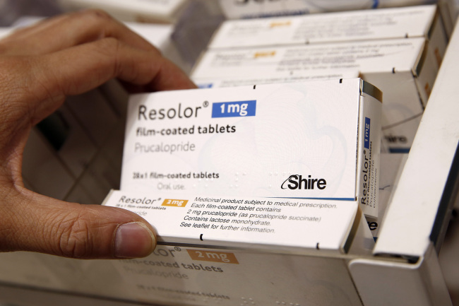 A pharmacist removes a box of Shire Resolor 1 mg prolonged film-coated tablets from a storage drawer at a pharmacy in London. (Bloomberg)