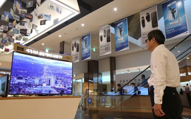 A man watches a TV at Samsung Electronics’ D’light exhibition hall installed at the firm’s headquarters in southern Seoul. (Samsung Electronics)