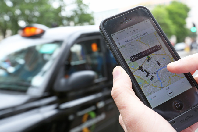 A user scans for an available vehicle using the Uber application in London. (Bloomberg)