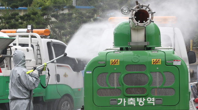 An official sprays disinfectant at a checkpoint in Uiseong, North Gyeongsang Province, where the first case of foot-and-mouth disease since the April 2011 outbreak was confirmed on Thursday. About 600 pigs were slaughtered at the Uiseong farm, and the authorities launched a multi-organization response to contain the outbreak. (Yonhap)