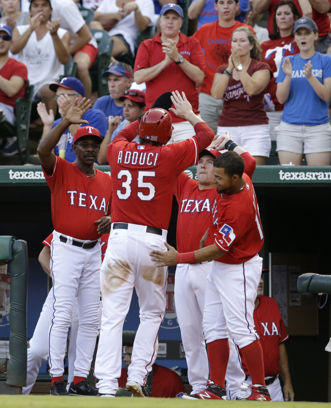 The Texas Rangers’ Jim Adduci is congratulated after scoring a run in the fourth inning on Saturday. (AP-Yonhap)