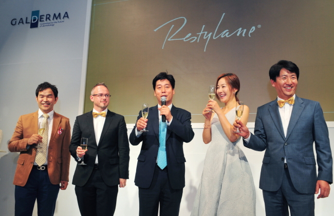 Galderma Asia-Pacific director Scott Mclennan (second from left) poses with Korean actress Uhm Ji-won (second from right), who was named the brand ambassador, and other executives at Beyond Museum in Seoul last week to celebrate Restylane’s global sales of 20 million units. (Galderma Korea)