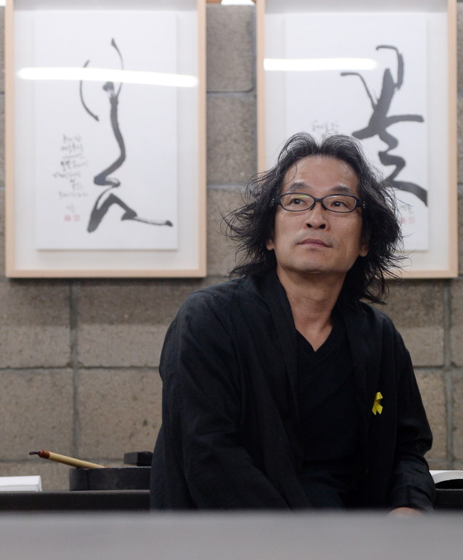 Contemporary Hangeul calligrapher Kang Byung-in poses at his studio near Hongdae. (Ahn Hoon/The Korea Herald)