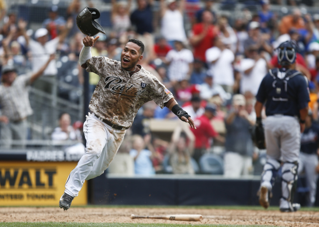 San Diego Padres’ Alexi Amarista throws his helmet in the air as he scores the game-winning run on a single by Everth Cabrera in the 10th inning against the Atlanta Braves on Sunday. (AP-Yonhap)