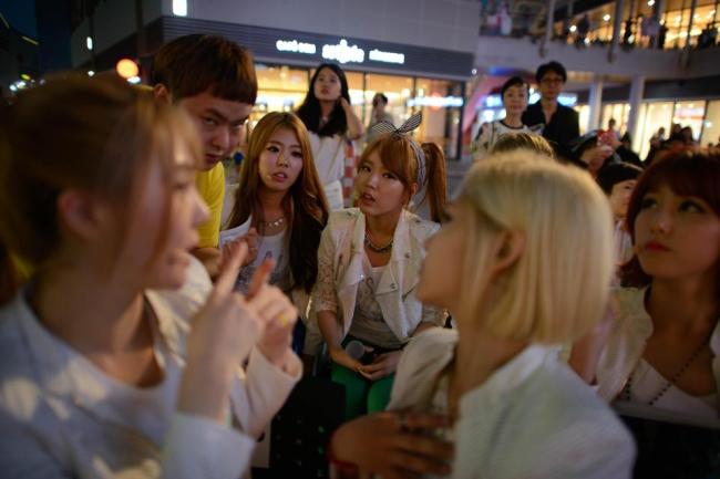 Manager Park In-Seo (2nd L) talks to K-pop group 'Billion' members Ki-Ryeon (L), Janet (centre L), Betty (centre R), Ray (2nd L), and Seul-gi (R) prior to a performance at a shopping mall in Ilsan, near Seoul, June 10, 2014.  (AFP)