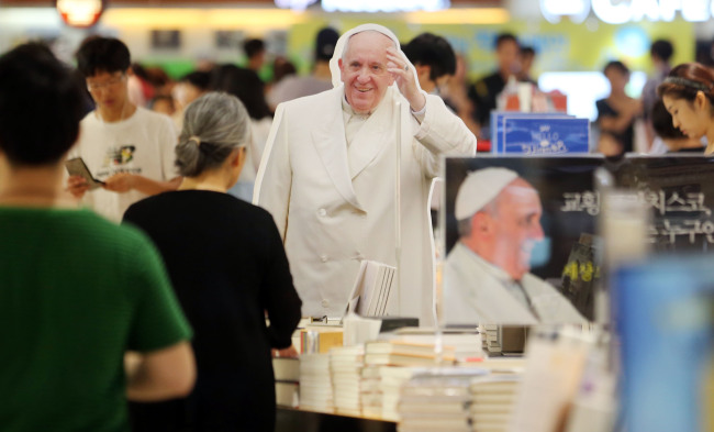Life-size cut-outs of the pope greet people as they enter a section dedicated to 30 or more different kinds of books on the pope at a large bookstore in Korea. (Yonhap)