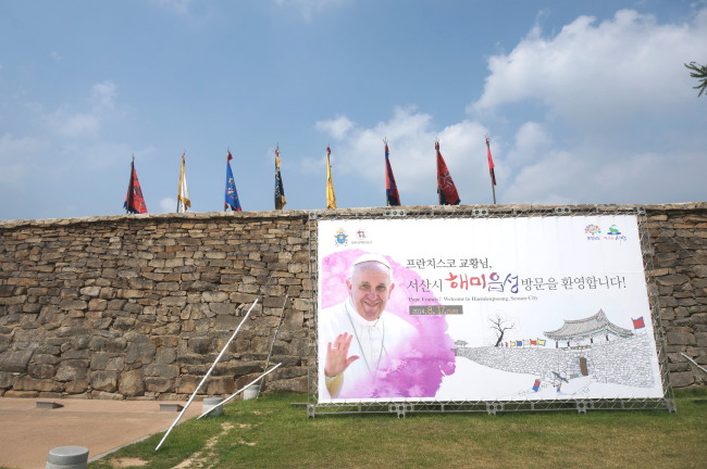 A placard welcoming Pope Francis hangs on the Haemi-eup Wall, where the pope will hold a Mass on Aug. 17. (Lee Woo-young/The Korea Herald)