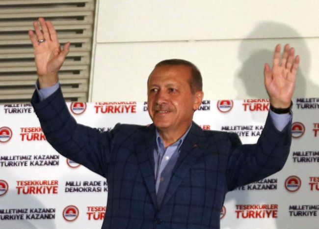 Recep Tayyip Erdogan waves at supporters from the balcony of the AKP party headquarters during the celebrations of his victory in the presidential election vote in Ankara on Sunday. (AFP-Yonhap)