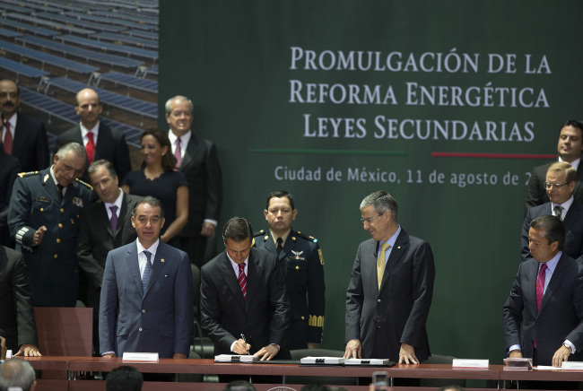 Enrique Pena Nieto (center), president of Mexico, signs legislation during a ceremony in Mexico City on Monday. (Bloomberg)