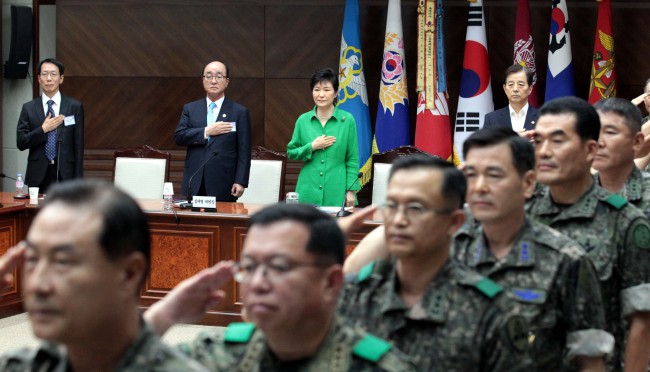 President Park Geun-hye and military leaders pledge allegiance to the national flag as a meeting of top commanders begins at the Ministry of National Defense in Seoul on Wednesday. (Park Hyun-koo/The Korea Herald)