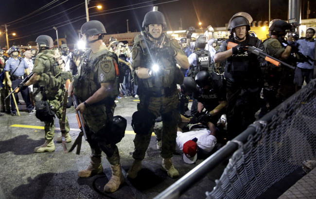 Police officers stand guard as they arrest a protestor in Ferguson, Missouri, Tuesday. (AP-Yonhap)