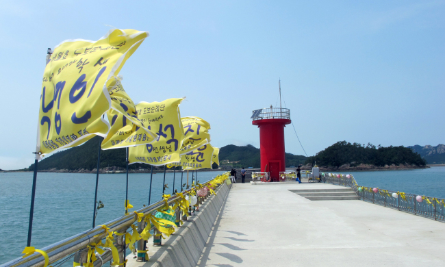 Yellow flags with prayers for the return of 10 missing students from the Sewol ferry disaster wave in the wind along the pier at Paengmok harbor on Jindo Island where search-and-rescue operations are still running. (Yonhap)