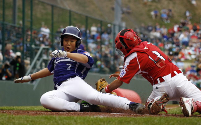 Korea’s Jeon Jin-woo slides to score a run in the second inning against Japan on Saturday. (AP-Yonhap)