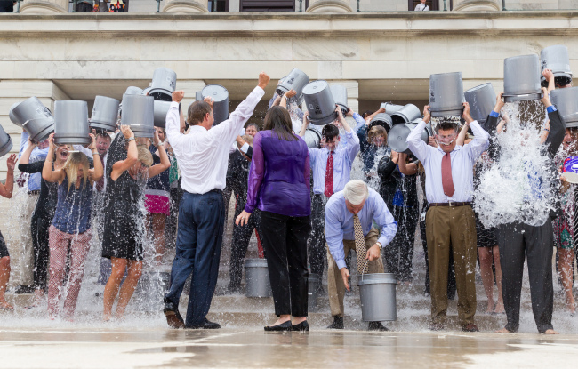 Tennessee Gov. Bill Haslam and his wife cheer on staff as they douse themselves with cold water on the steps of the state Capitol in Nashville, Tennessee, Friday. The Haslams were participating in the Ice Bucket Challenge to support research into amyotrophic lateral sclerosis, also known as Lou Gehrig’s disease. (AP-Yonhap)