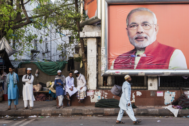 A pedestrian walks past a billboard of India’s Prime Minister Narendra Modi in New Delhi. (Bloomberg)