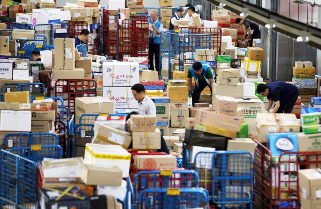 Delivery people sort out gift parcels for Chuseok at Korea Post’s distribution center in Seoul on Tuesday. This year the Chuseok holiday falls on Sept. 8. (Yonhap)