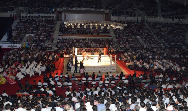 North Koreans watch a pro wrestling exhibition in Pyongyang on Saturday. (Yonhap)