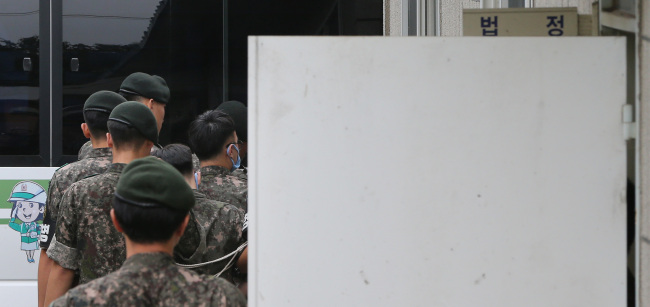 Soldiers who allegedly beat a pfc to death in April enter a military courtroom early last month. (Yonhap)