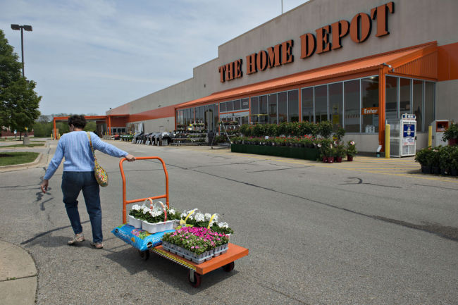 A customer pulls a cart of flowers outside a Home Depot Inc. store in Peoria, Illinois. (Bloomberg)