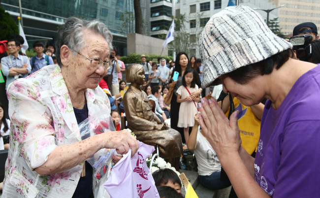 Gil Won-ok (left), a former “comfort woman,” greets a Japanese activist during a rally in front of the Japanese Embassy in central Seoul on Aug. 20. (Yonhap)